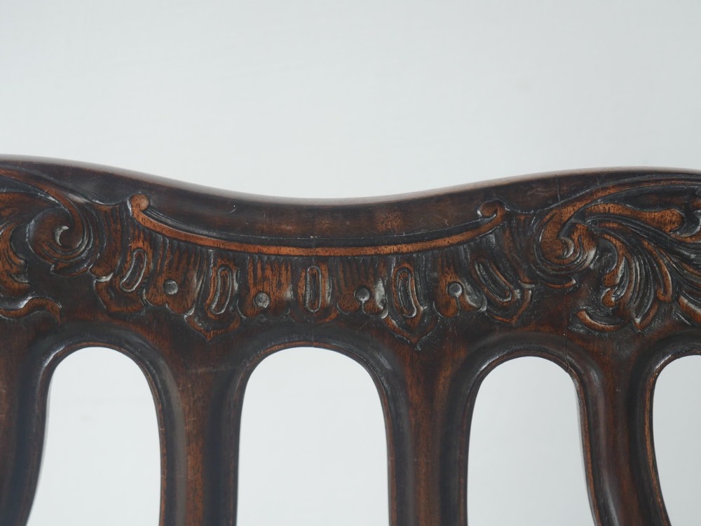 A carved mahogany armchair featuring an ornate pierced splat back, scrolled arms, tan striped fabric upholstery, and cabriole front legs with claw-and-ball feet. View XI