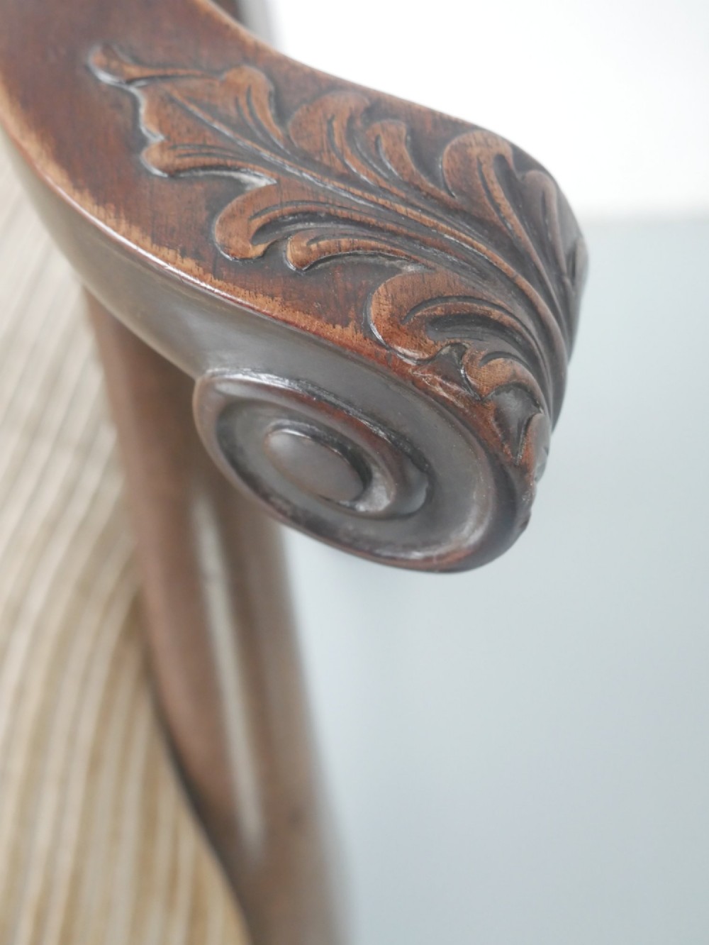 A carved mahogany armchair featuring an ornate pierced splat back, scrolled arms, tan striped fabric upholstery, and cabriole front legs with claw-and-ball feet. View XIII