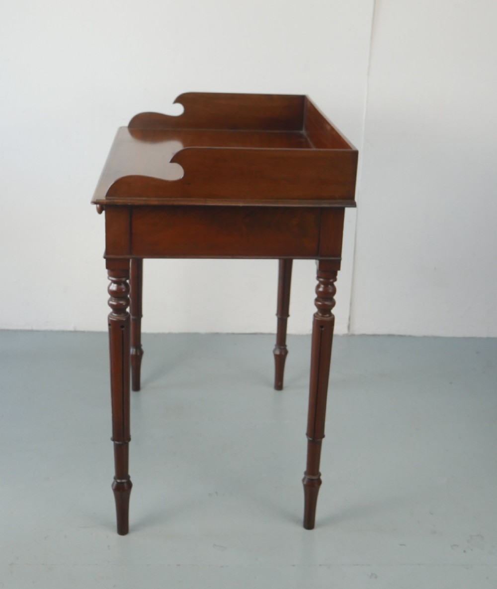 A 19th-century mahogany writing table featuring turned legs, a single frieze drawer with wooden knobs, and a raised gallery back. View III