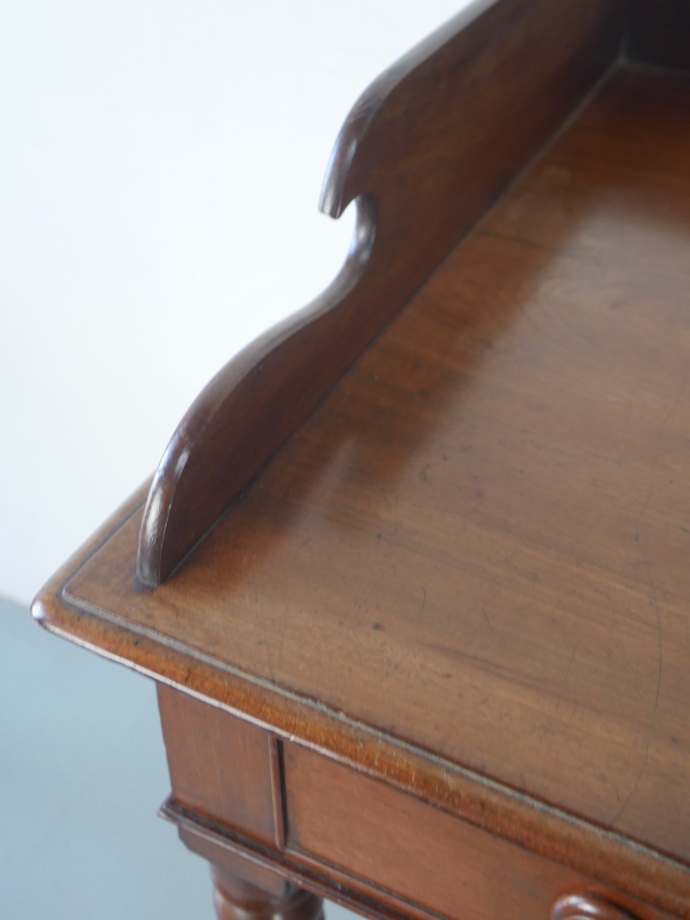 A 19th-century mahogany writing table featuring turned legs, a single frieze drawer with wooden knobs, and a raised gallery back. View VIII