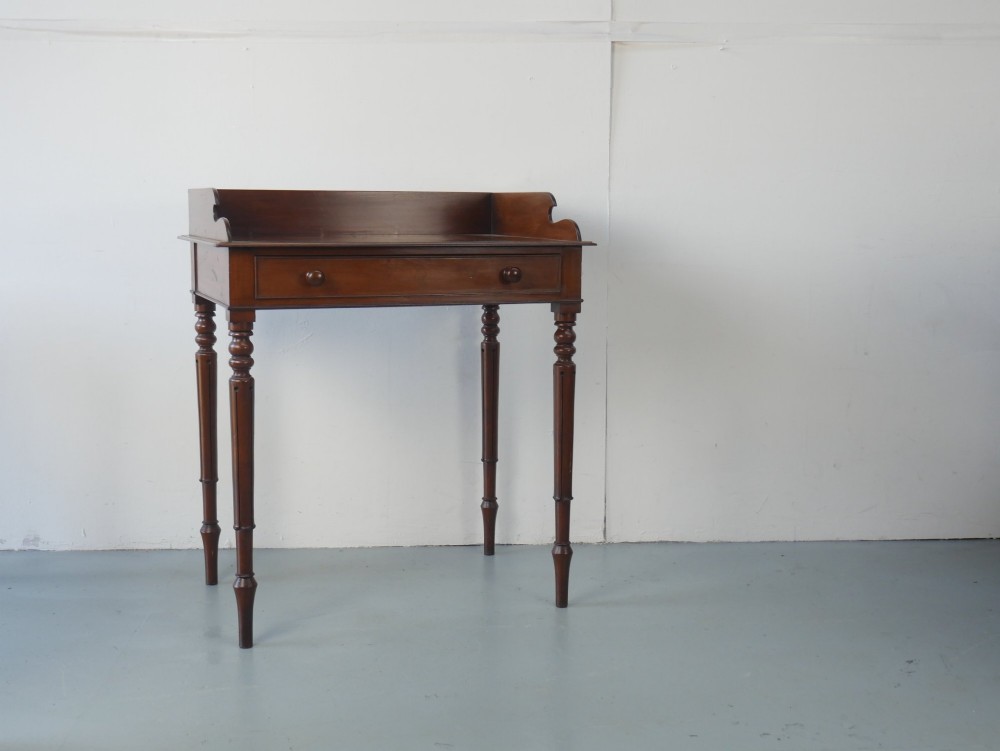 A 19th-century mahogany writing table featuring turned legs, a single frieze drawer with wooden knobs, and a raised gallery back. View XII