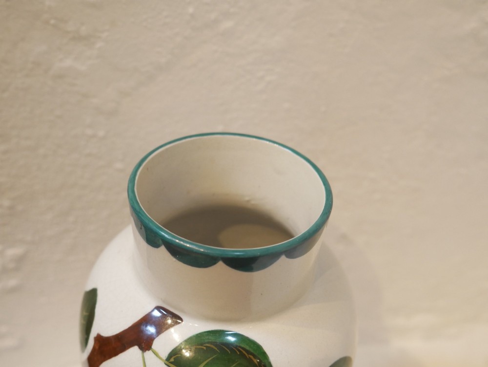 A cylindrical cream earthenware vase hand-painted with green leaves, yellow apples, and a green scalloped rim detail. View IV