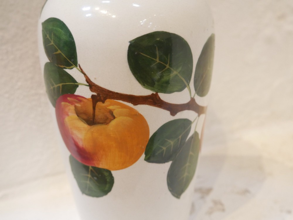 A cylindrical cream earthenware vase hand-painted with green leaves, yellow apples, and a green scalloped rim detail. View VI