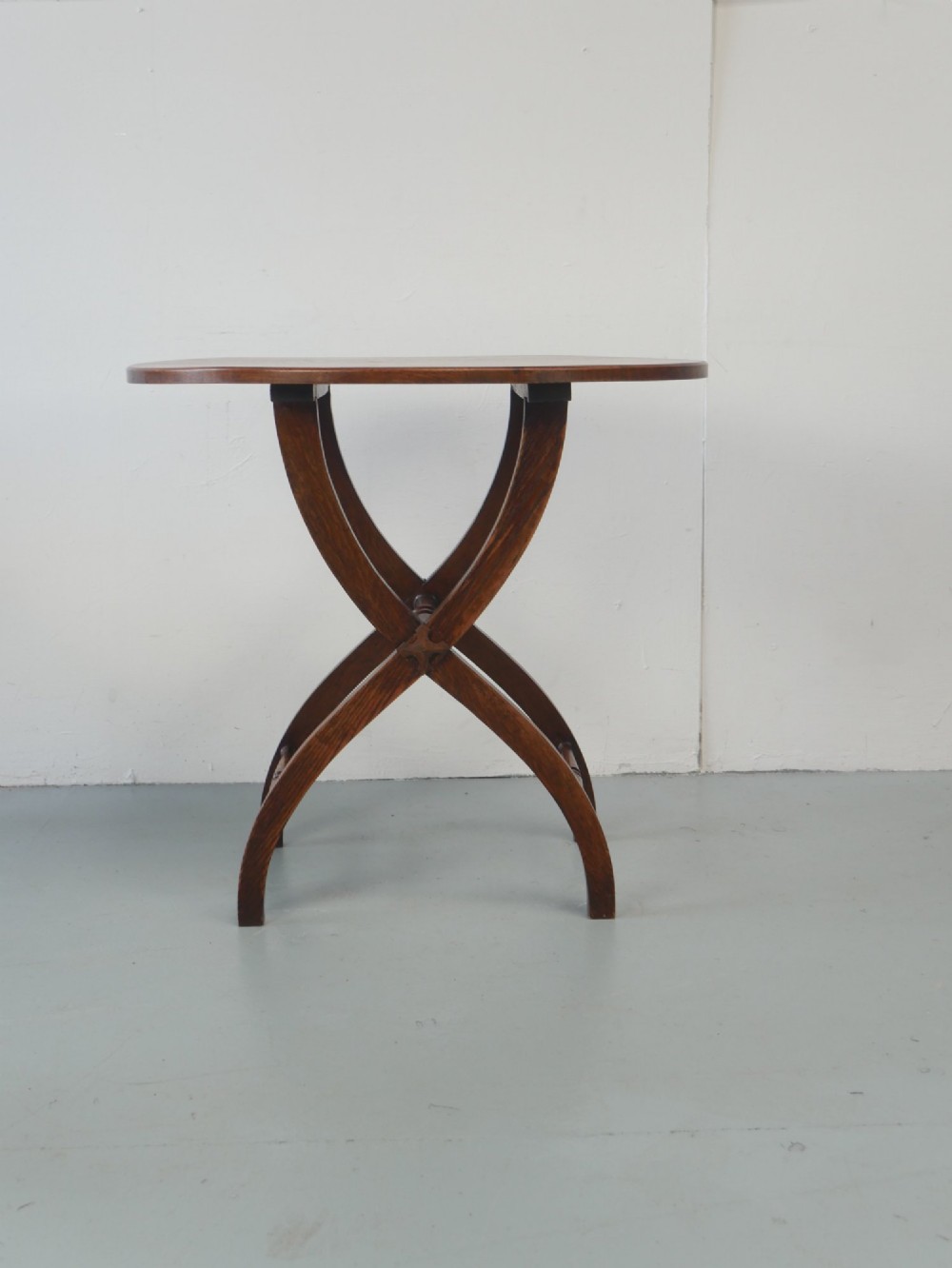 A circular oak lamp table featuring curved cross-framed legs joined by turned stretchers. View II