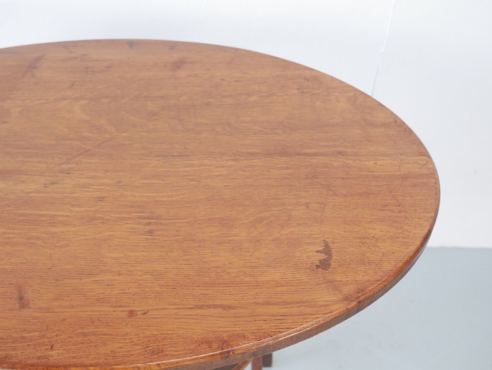 A circular oak lamp table featuring curved cross-framed legs joined by turned stretchers. View IV