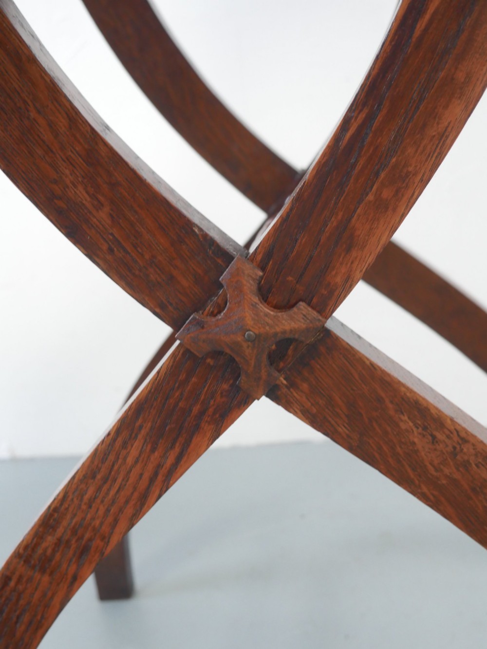 A circular oak lamp table featuring curved cross-framed legs joined by turned stretchers. View VII