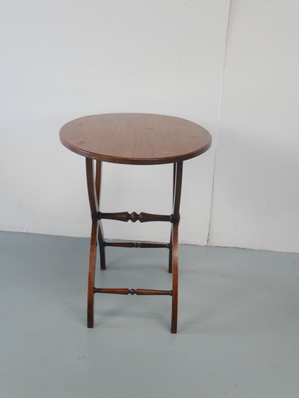 A circular oak lamp table featuring curved cross-framed legs joined by turned stretchers. View VIII