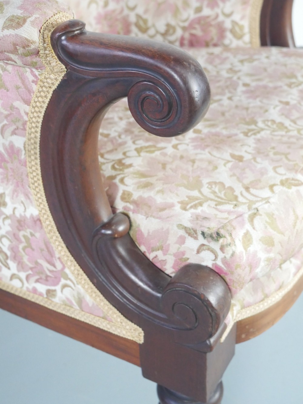 A Regency mahogany armchair with floral patterned fabric upholstery, scroll arms, reeded front legs, and brass castors. View VI