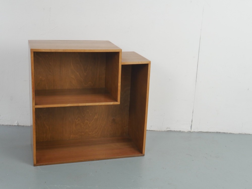 A mid-century open wooden side cabinet featuring asymmetrical shelving compartments and visible comb joints at the outer edges. View IX