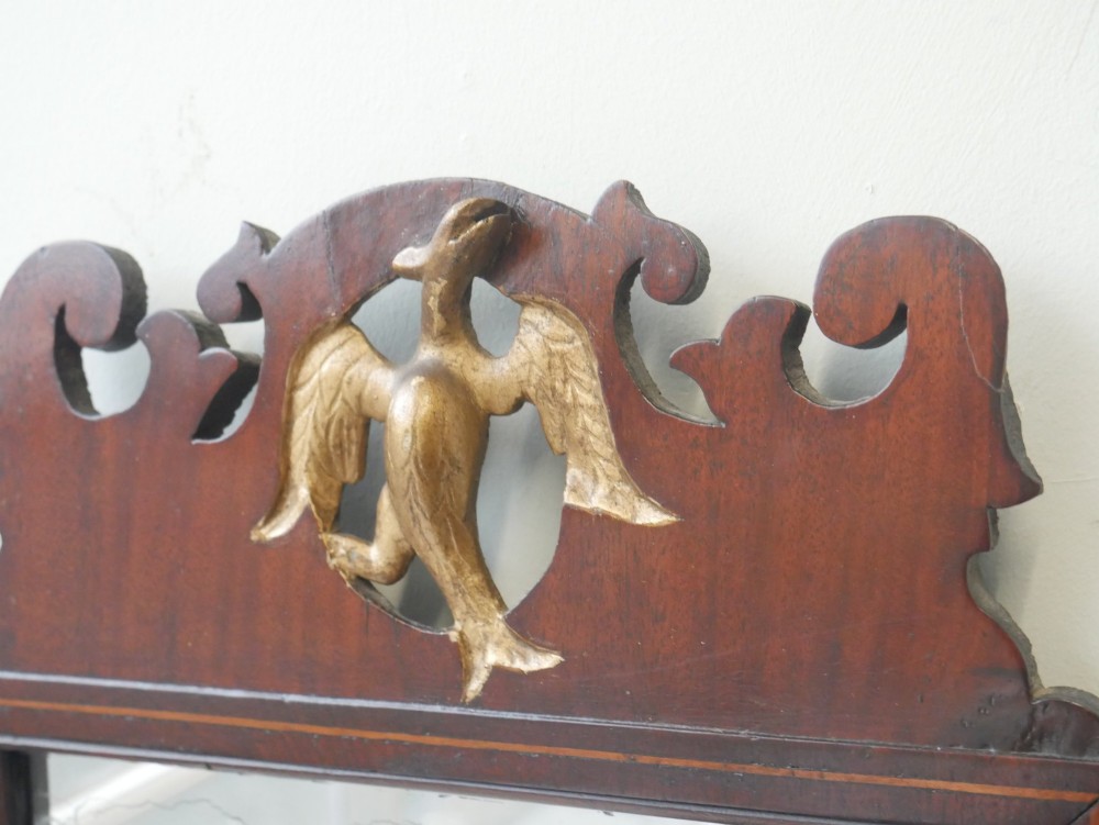 A petit Georgian mahogany wall mirror featuring a pierced fretwork frame topped with a gilded eagle crest. View II