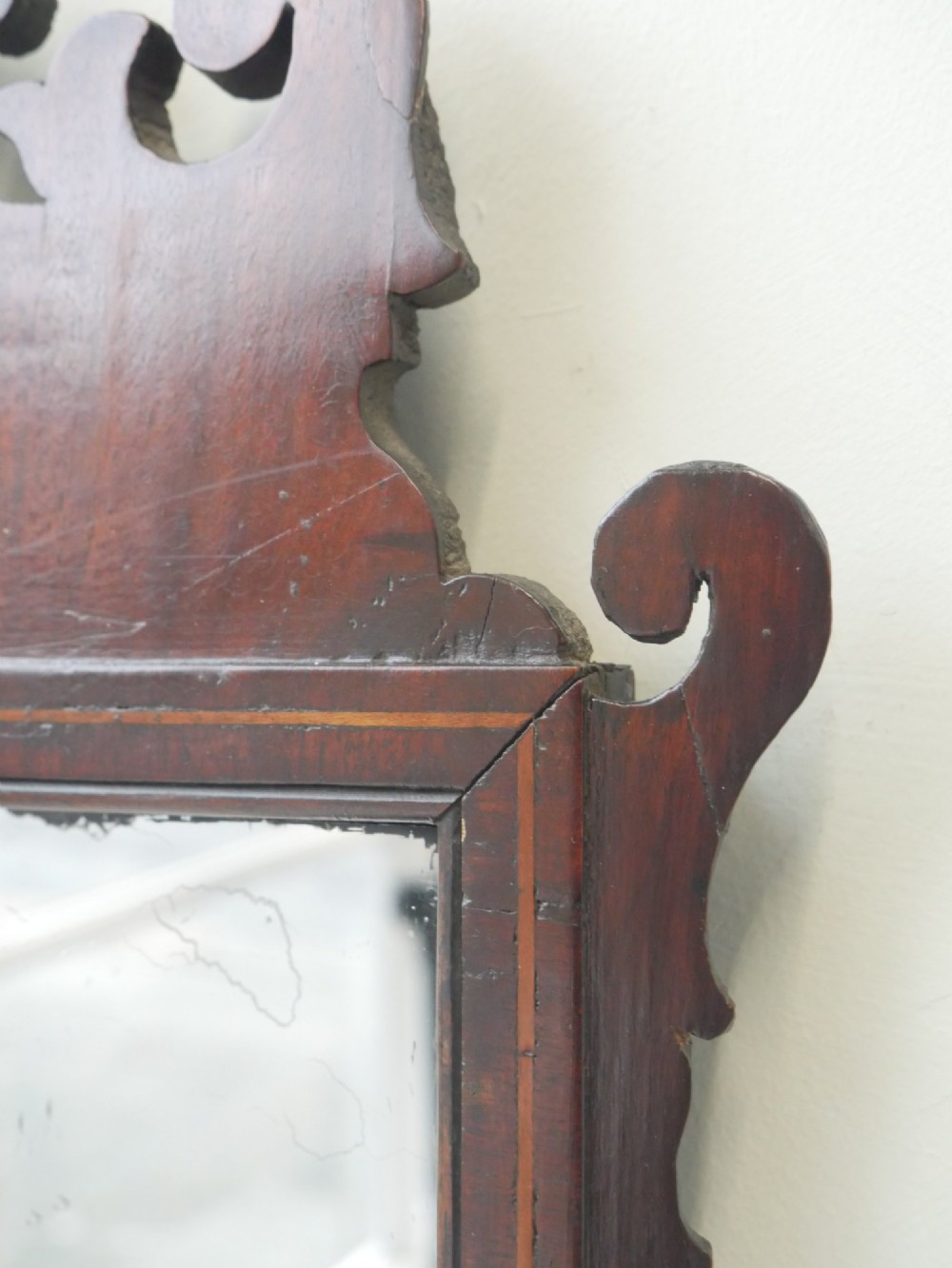 A petit Georgian mahogany wall mirror featuring a pierced fretwork frame topped with a gilded eagle crest. View III