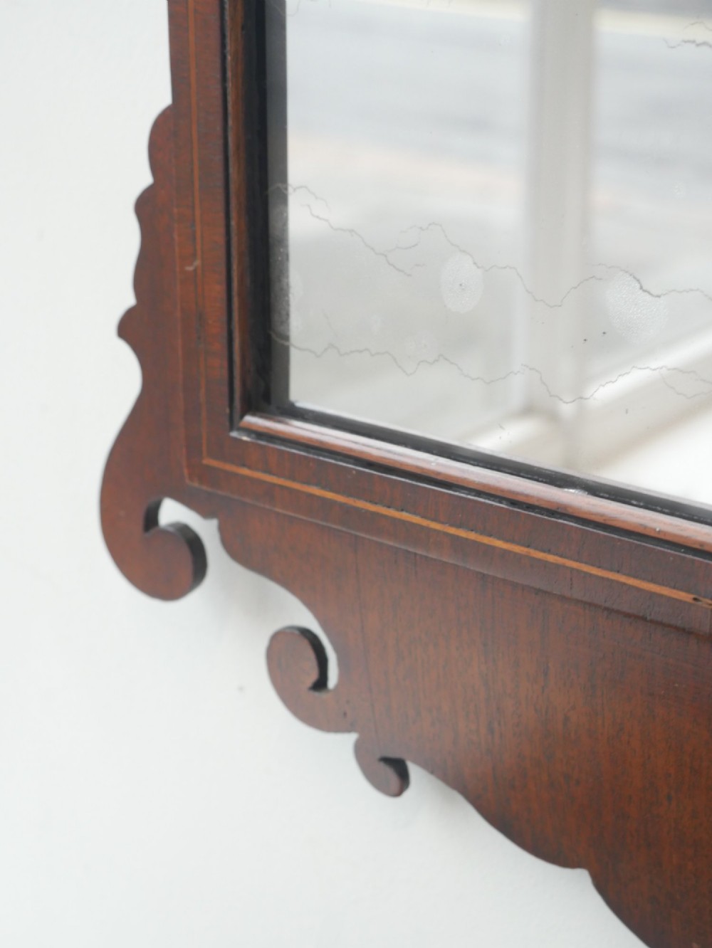 A petit Georgian mahogany wall mirror featuring a pierced fretwork frame topped with a gilded eagle crest. View V