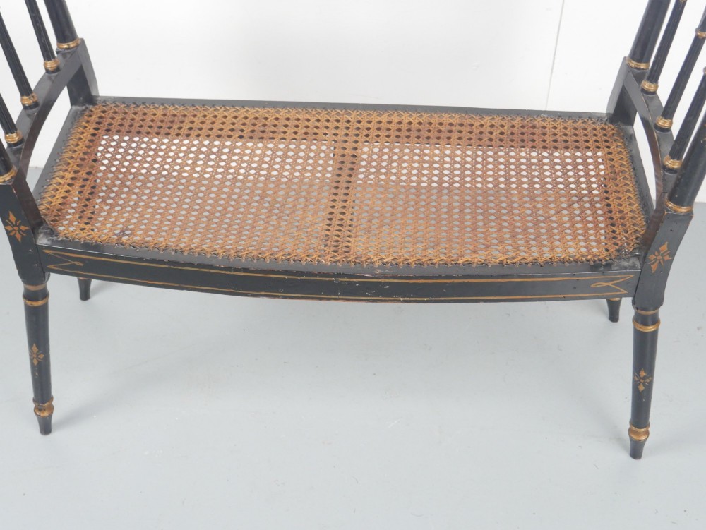 A black painted and parcel-gilt antique Sheraton window seat featuring pointed arch end splats and a floral needlepoint cushion. View VI