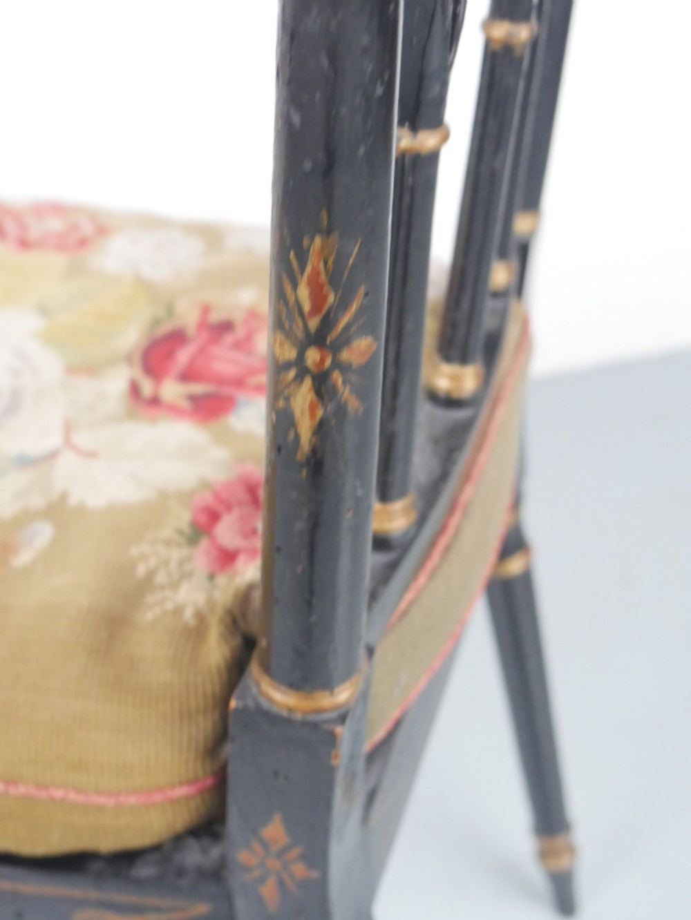 A black painted and parcel-gilt antique Sheraton window seat featuring pointed arch end splats and a floral needlepoint cushion. View IX