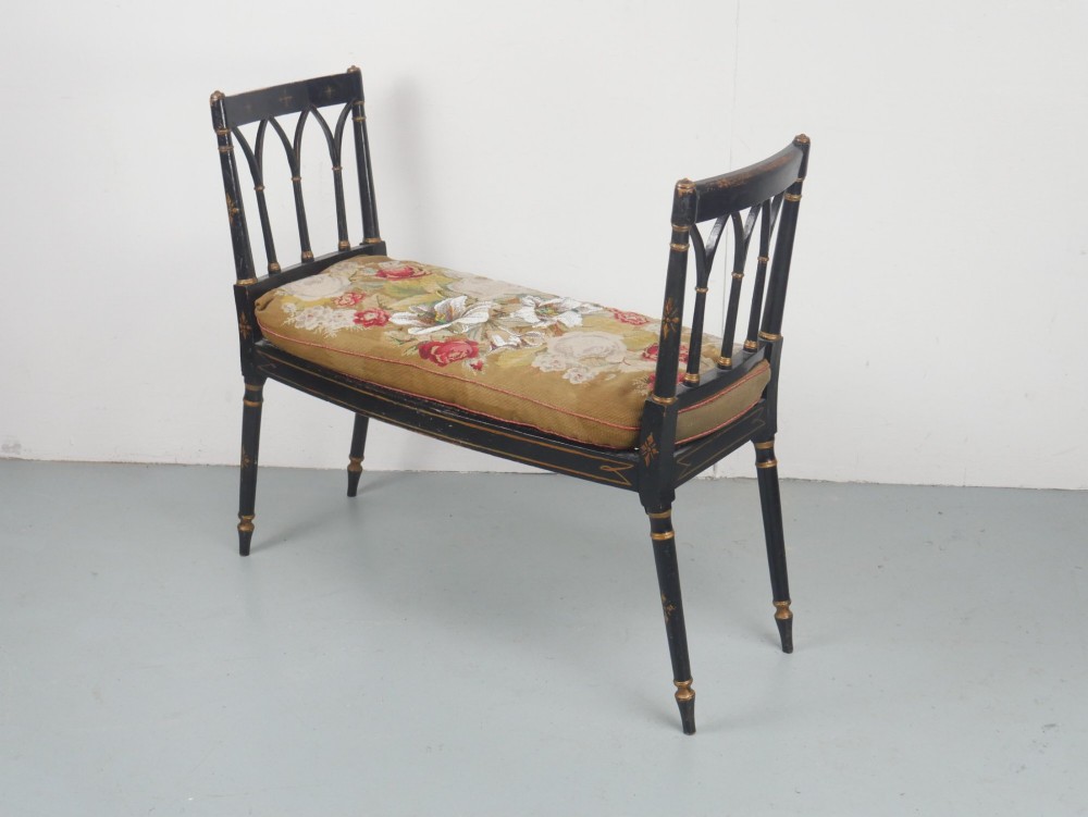 A black painted and parcel-gilt antique Sheraton window seat featuring pointed arch end splats and a floral needlepoint cushion. View XI