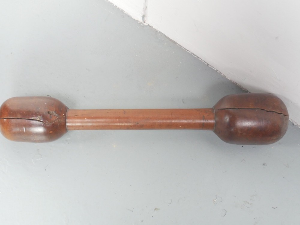 A large turned wooden mortar with ribbed bands on its exterior and a matching pestle resting inside. View IV