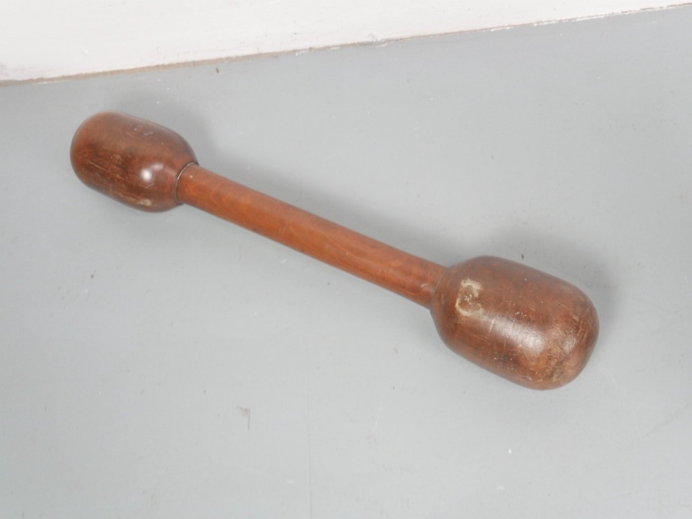 A large turned wooden mortar with ribbed bands on its exterior and a matching pestle resting inside. View V