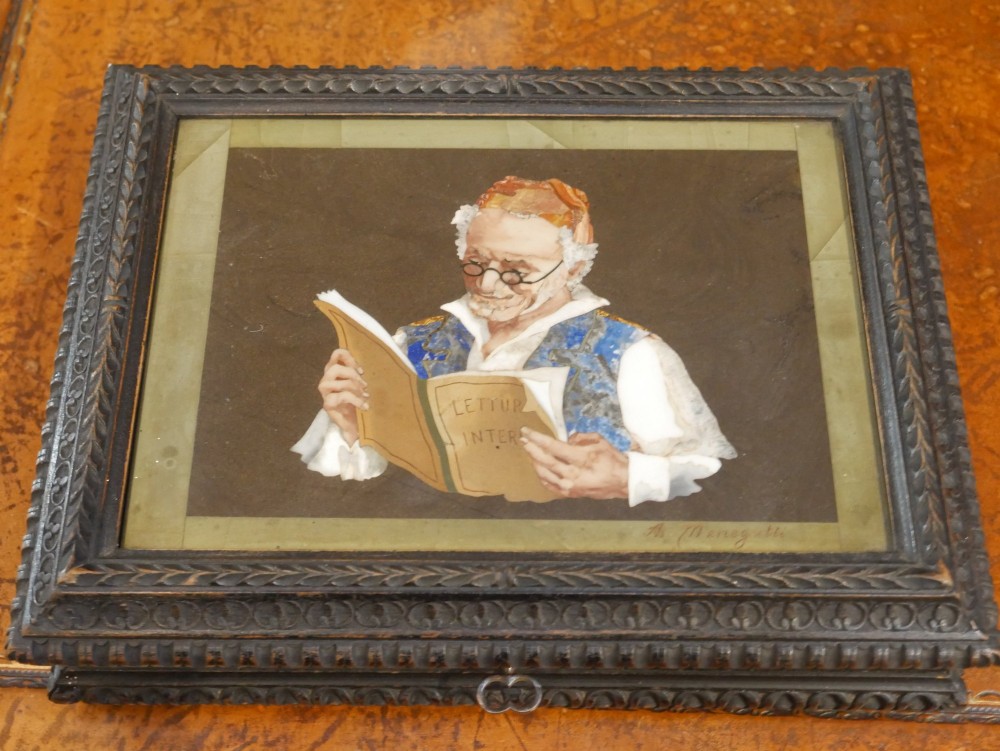 A rectangular dark carved wooden box featuring a detailed pietra dura hardstone inlay depicting an elderly man in spectacles reading a book.