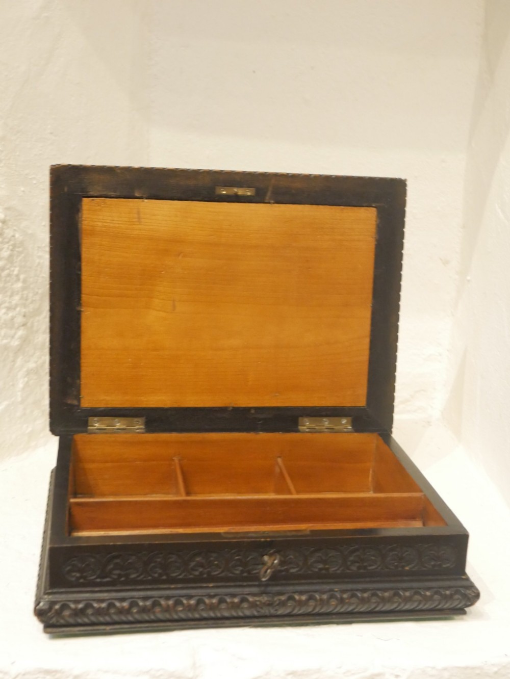 A rectangular dark carved wooden box featuring a detailed pietra dura hardstone inlay depicting an elderly man in spectacles reading a book. View II