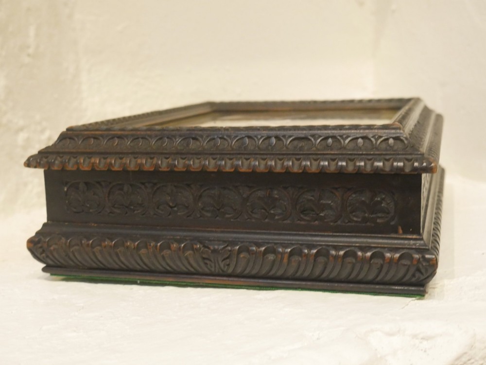 A rectangular dark carved wooden box featuring a detailed pietra dura hardstone inlay depicting an elderly man in spectacles reading a book. View VII