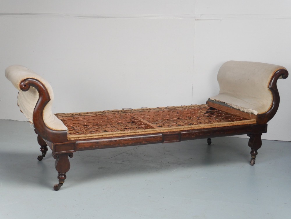 An early nineteenth-century Regency mahogany scroll-ended sofa frame featuring brass mounts, reeded turned legs on brass castors, and upholstered end scrolls with exposed spring seating. View XI
