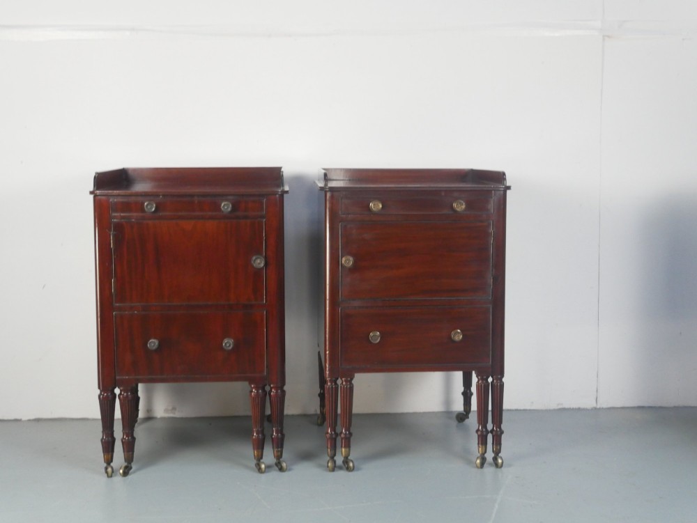 A matched pair of dark mahogany Regency bedside cupboards featuring gallery tops, single cupboard doors, lower drawers, reeded legs, and brass castors. View III