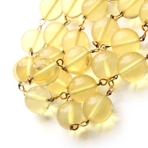 fig 1. A mid-century necklace featuring spherical translucent yellow Lucite beads connected by brass wire links with a box clasp.
