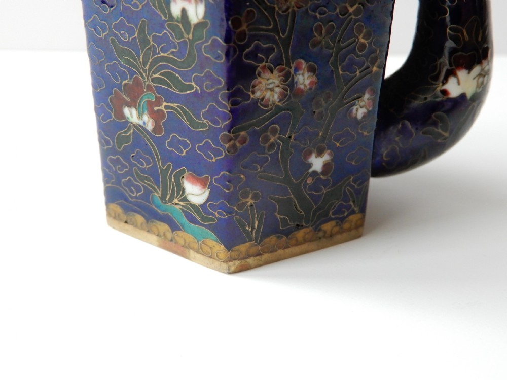A hexagonal Chinese cloisonne enamel teapot featuring a navy blue body with floral motifs, gold wirework, and a fitted brass lid. View III