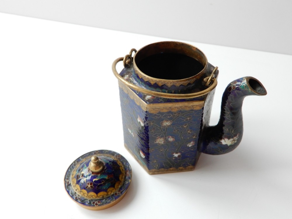 A hexagonal Chinese cloisonne enamel teapot featuring a navy blue body with floral motifs, gold wirework, and a fitted brass lid. View V