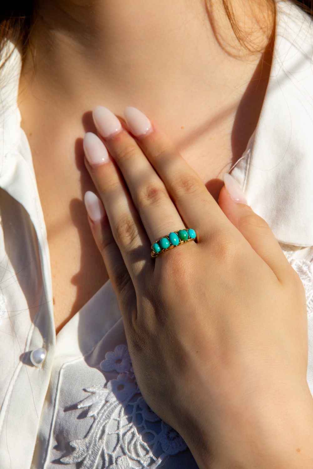 An antique 18ct yellow gold ring featuring five graduated cabochon turquoise stones set in a carved band. View VII