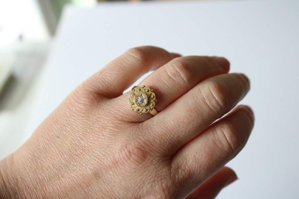 An antique 9ct yellow gold ring featuring a central star-set diamond surrounded by intricate Etruscan revival beaded and scalloped detail. View VI
