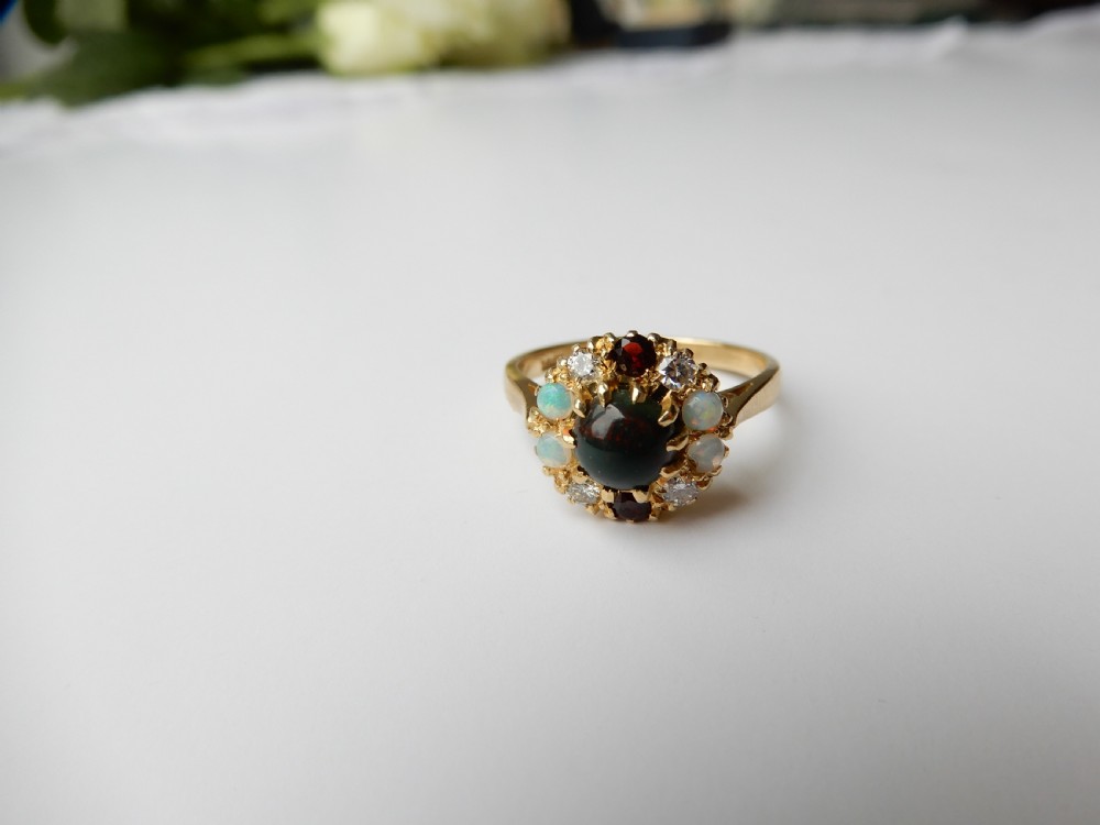 An antique yellow gold cluster ring set with a central cabochon bloodstone surrounded by alternating opals, garnets, and diamonds. View III