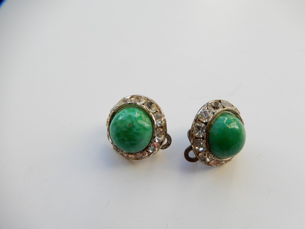 A pair of circular clip-on earrings featuring domed green Peking glass cabochons bordered by a halo of clear rhinestones in silver-tone settings. View II
