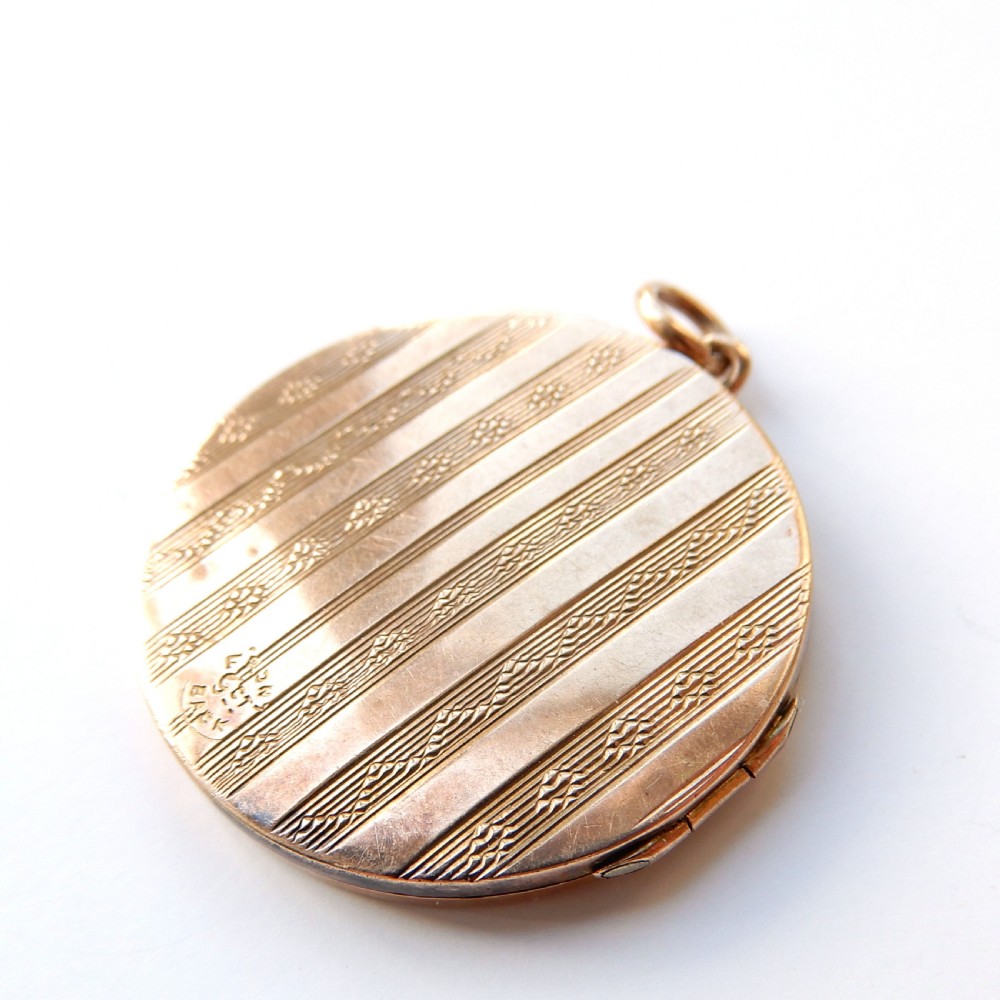 A round 9ct gold back and front locket featuring engine-turned diagonal line engraving and an unengraved central circular cartouche. View VIII