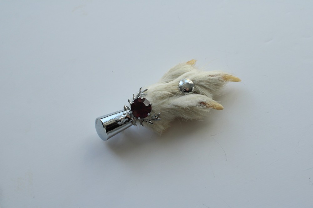 A Scottish grouse foot brooch mounted in a silver-tone metal cap featuring a faceted purple rhinestone. View III