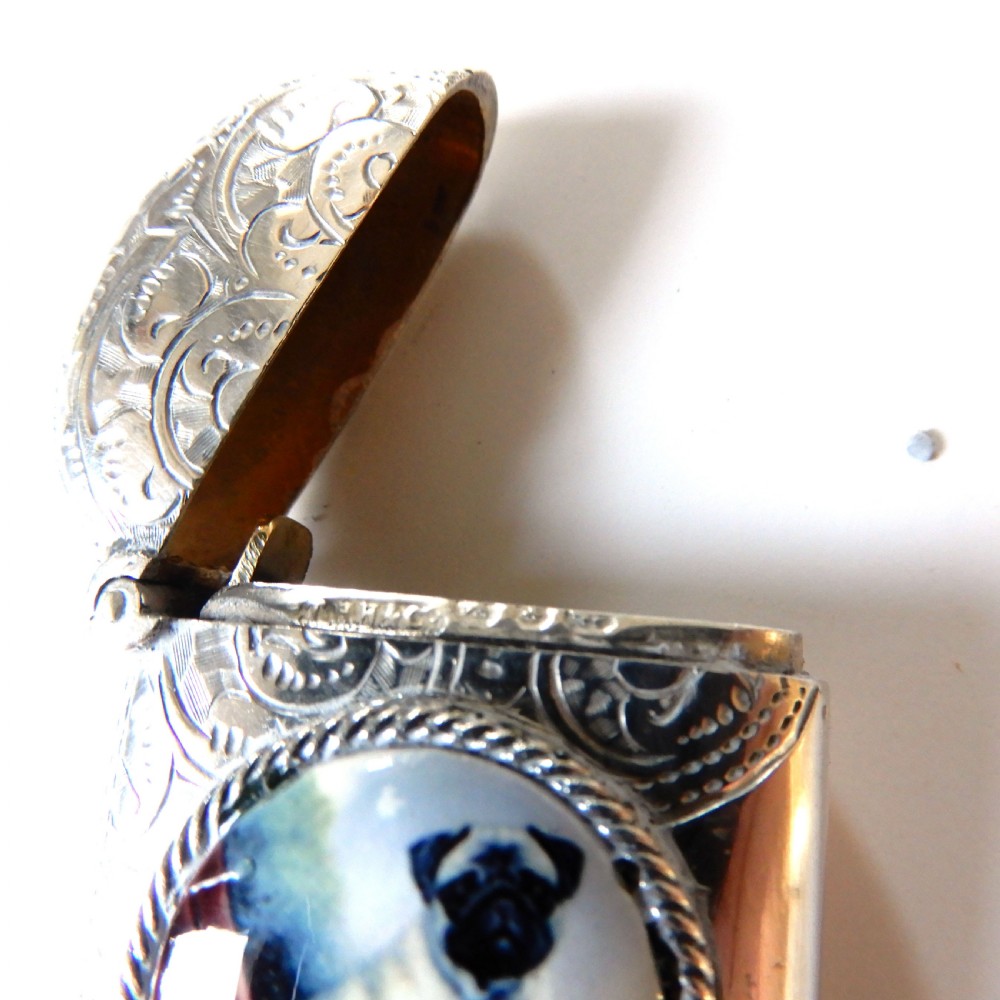 A sterling silver vesta case featuring an engraved top section, a rope-twist border, and a central enamel plaque depicting a sitting pug dog. View V