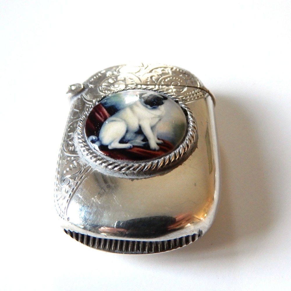 A sterling silver vesta case featuring an engraved top section, a rope-twist border, and a central enamel plaque depicting a sitting pug dog. View VII