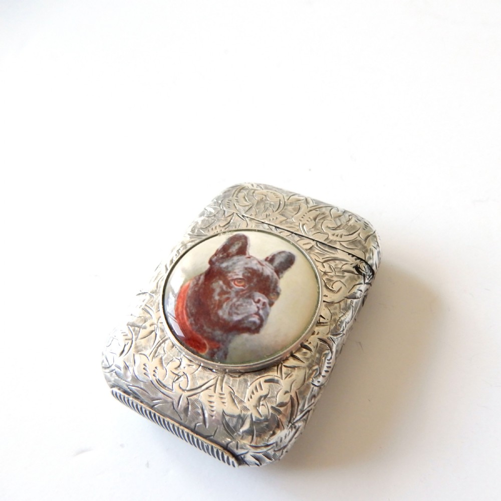 An antique Victorian sterling silver vesta case decorated with foliage engraving and a central circular enamel plaque depicting a French Bulldog. View IV