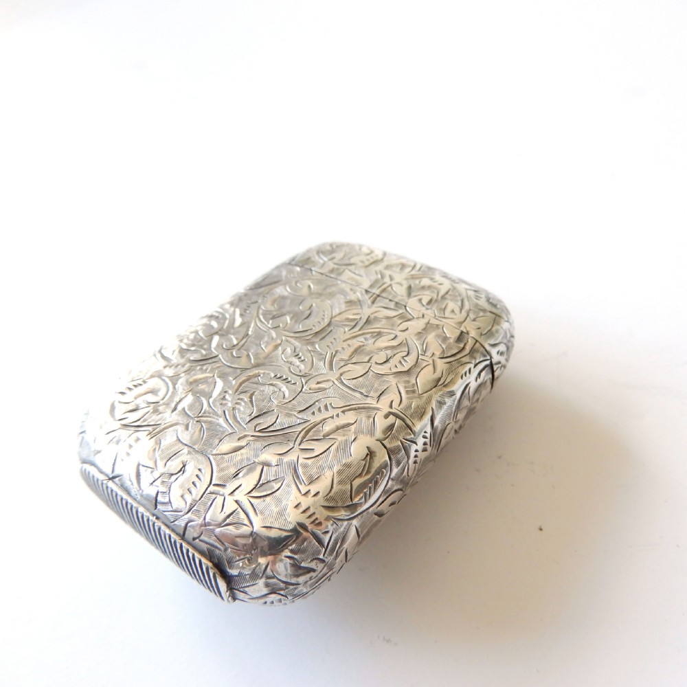 An antique Victorian sterling silver vesta case decorated with foliage engraving and a central circular enamel plaque depicting a French Bulldog. View VII
