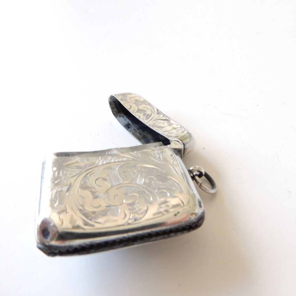 An Edwardian sterling silver vesta case with hand-engraved scrollwork and a central oval enamel depiction of a four-funnel ocean liner. View V