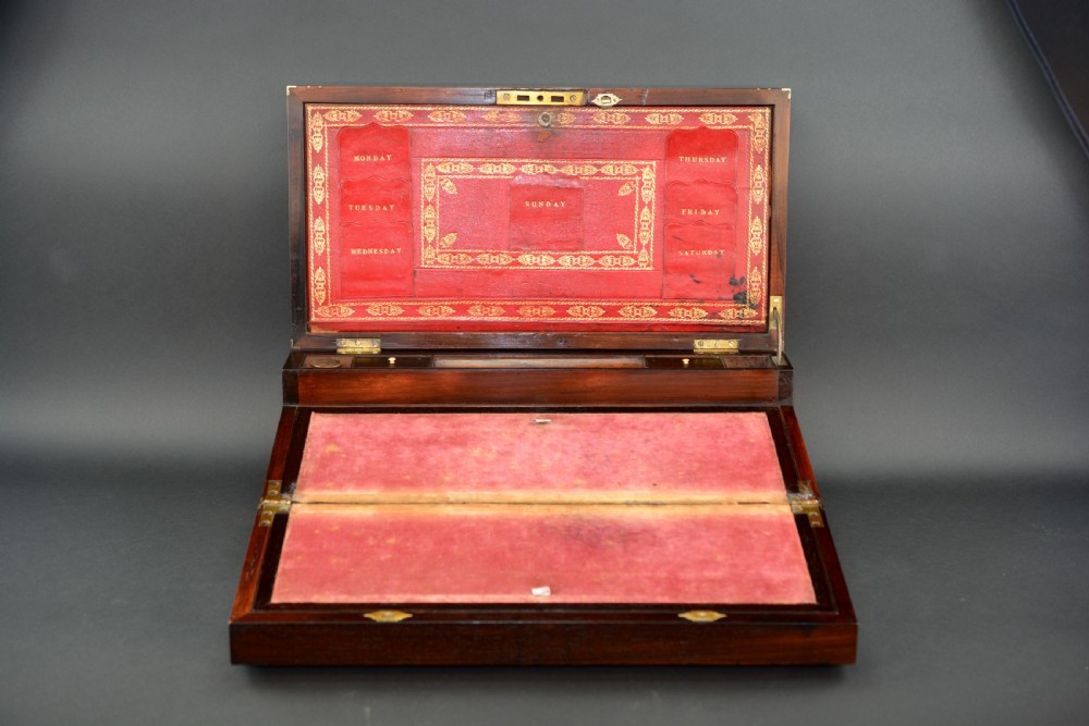 Top view of a rectangular dark rosewood writing slope decorated with brass border stringing and a central brass cartouche. View III