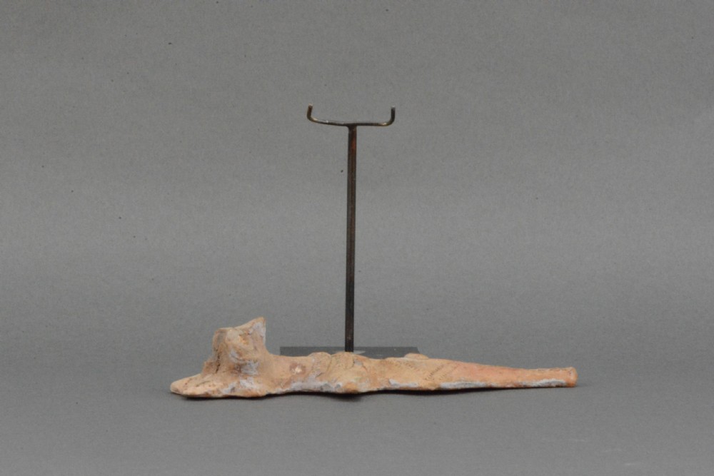 An ancient Syro-Hittite terracotta figure of the goddess Astarte featuring a bird-like face and incised geometric body markings mounted on a black stand. View IV