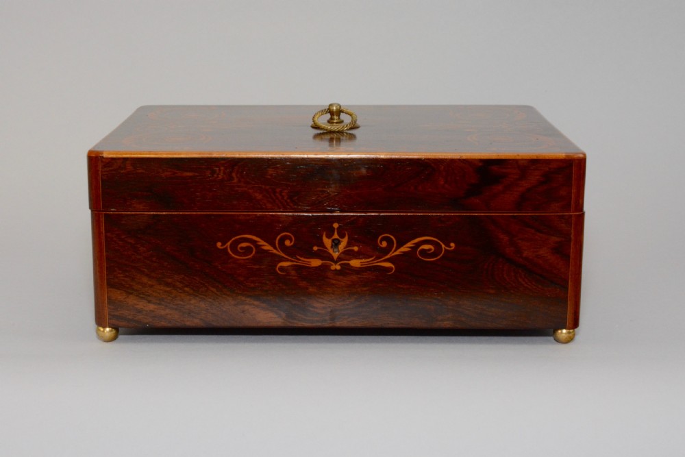 A rectangular dark reddish-brown rosewood box featuring fine wood marquetry around the keyhole, a top brass ring handle, and brass ball feet. View III