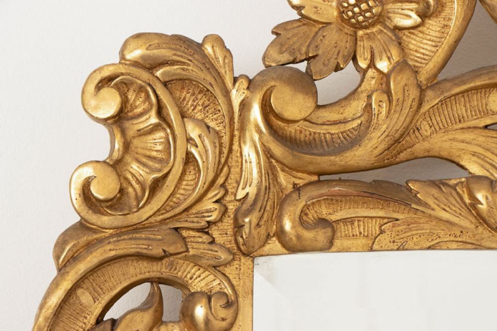 A 19th-century Italian giltwood wall mirror featuring an ornate carved floral cresting and rectangular bevelled glass. View III