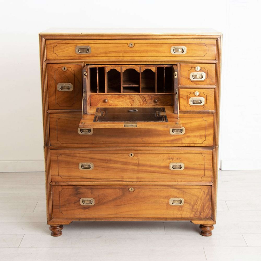An antique 19th-century camphorwood military campaign secretaire chest featuring flush brass handles, geometric drawer borders, and turned feet. View V