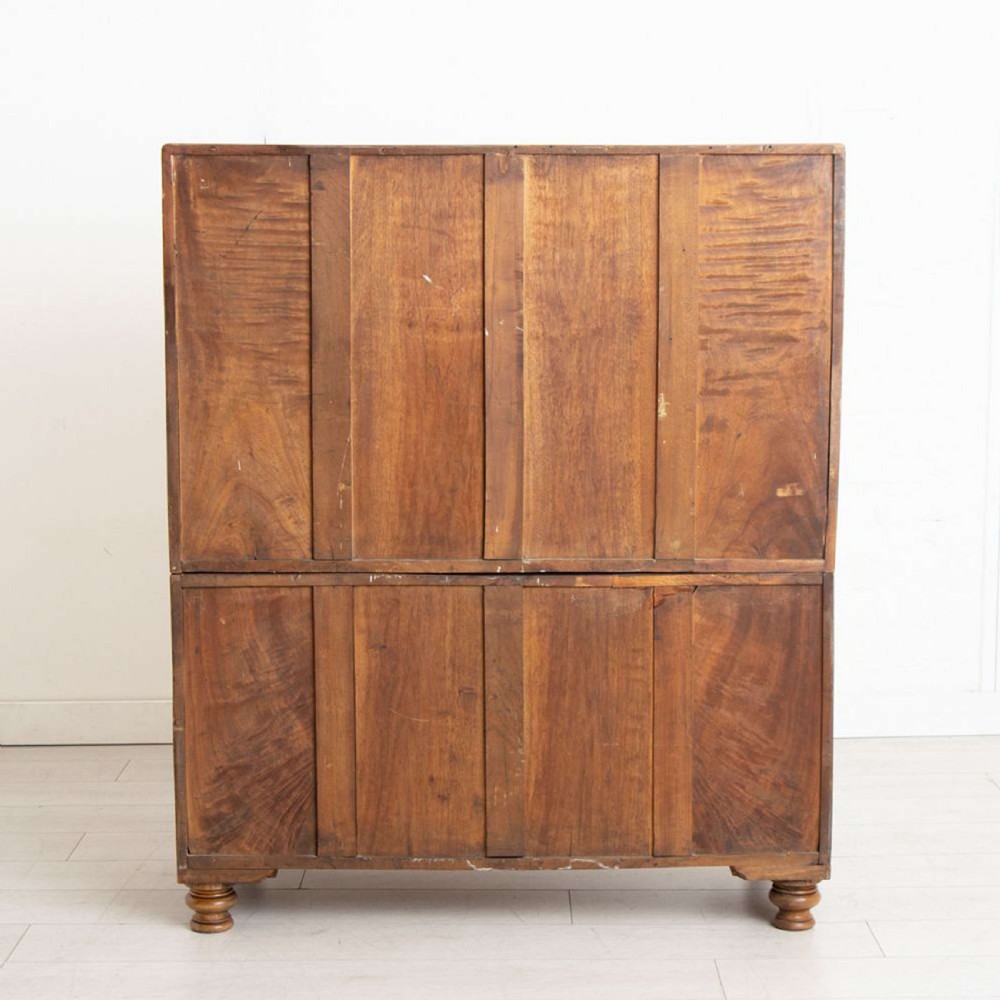 An antique 19th-century camphorwood military campaign secretaire chest featuring flush brass handles, geometric drawer borders, and turned feet. View VII
