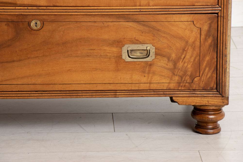 An antique 19th-century camphorwood military campaign secretaire chest featuring flush brass handles, geometric drawer borders, and turned feet. View IX