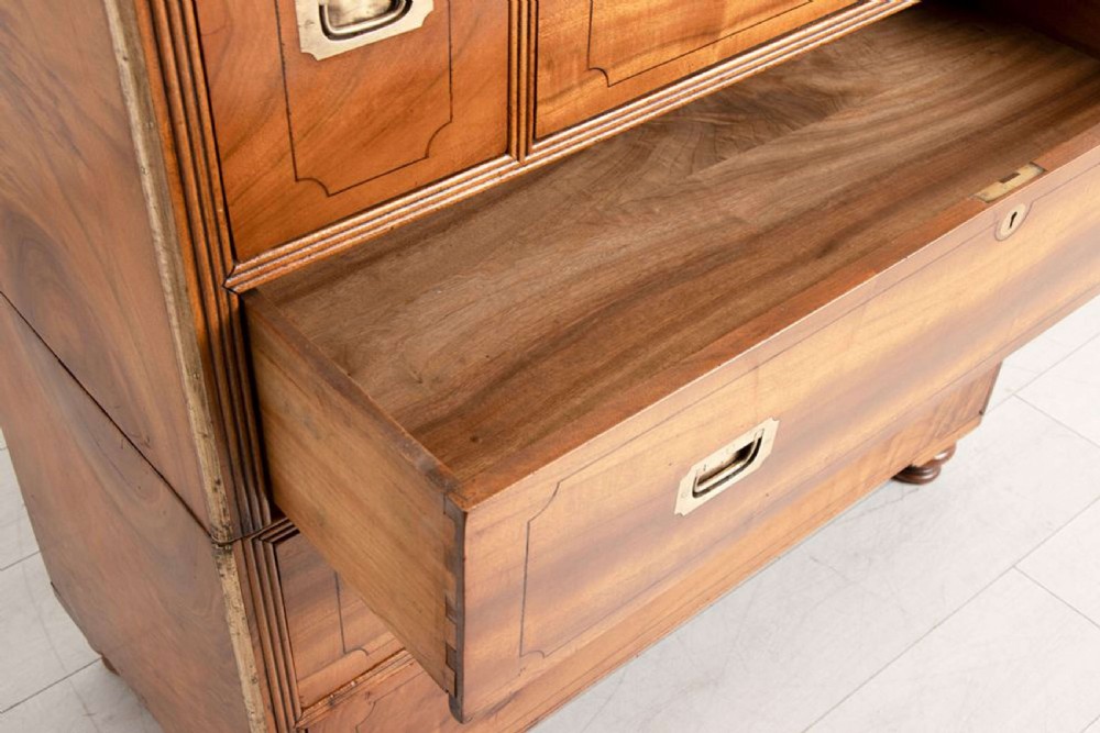 An antique 19th-century camphorwood military campaign secretaire chest featuring flush brass handles, geometric drawer borders, and turned feet. View XI