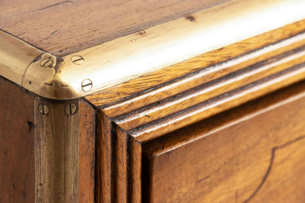An antique 19th-century camphorwood military campaign secretaire chest featuring flush brass handles, geometric drawer borders, and turned feet. View XII