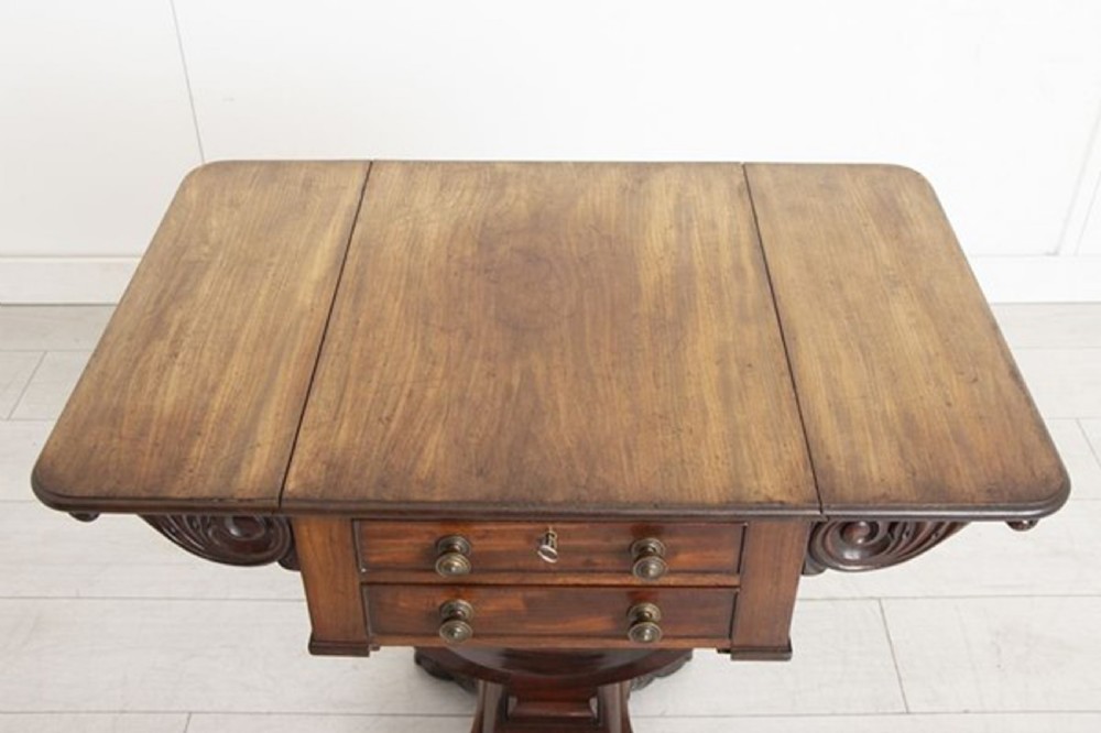 A small Georgian mahogany side table featuring drop leaves, two front drawers, a curved U-shaped support, and carved claw feet. View X